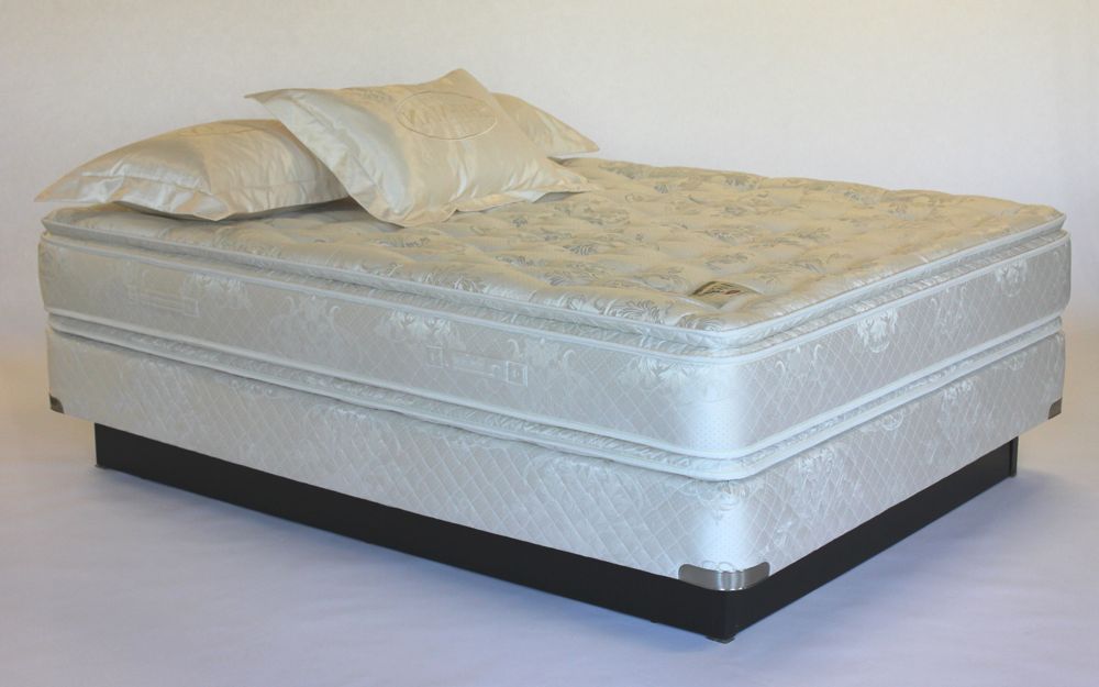 Matelas de lit double sur un sommier, avec deux oreillers